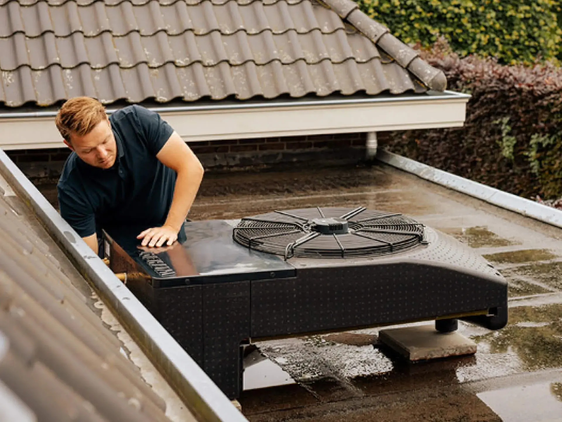 Monteur controleert een Weheat Blackbird warmtepomp op een plat dak